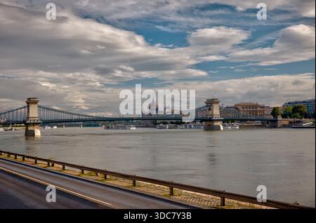 Pont des chaînes Széchenyi enjambant le Danube à Budapest, reflétant les nuages et l'architecture historique le long de la rive. Banque D'Images