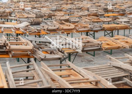 Tables en bois avec chaises en bois empilées disposées en rangées. Mobilier de restaurant extérieur préparé pour le stockage ou l'installation Banque D'Images