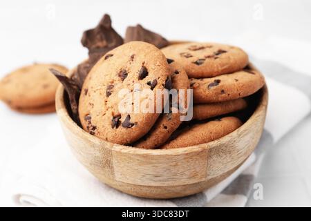 Délicieux biscuits aux pépites de chocolat et morceaux de chocolat dans un bol sur une table blanche, gros plan Banque D'Images