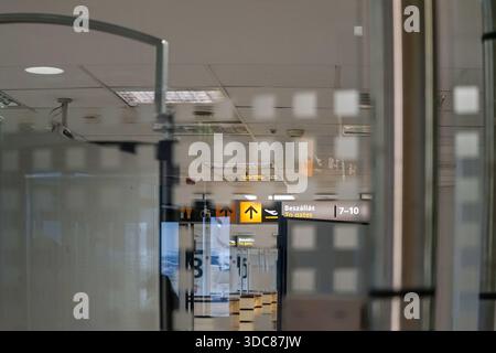 Couloir d'embarquement vide au terminal 1 de l'aéroport de Budapest avec numéros de porte, rangées de sièges et sols polis réfléchissants. Banque D'Images
