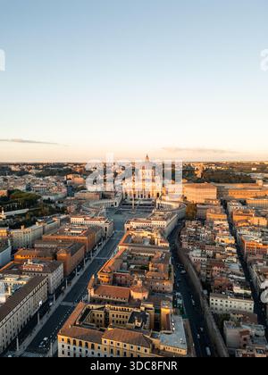 Découvrez la basilique Pierre et la place Saint-Pierre dans la Cité du Vatican, vue aérienne du drone sur le coucher du soleil mettant en valeur le dôme emblématique, l'architecture baroque et le surrou Banque D'Images