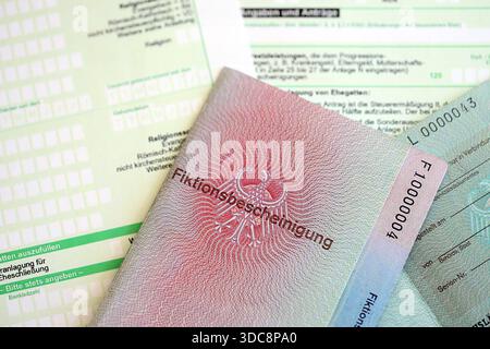 Le spécimen de carte de résident permanent temporaire allemand se trouve sur le formulaire fiscal allemand close up. Fiktionsbescheinigung et einkommensteuerklarung Banque D'Images