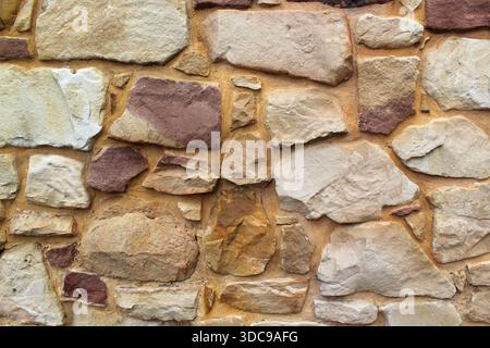 Mur avec des pierres de différentes formes et couleurs texturé fond abstrait Banque D'Images