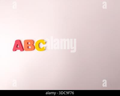 L'image montre des lettres colorées de l'alphabet, probablement en bois sur un fond blanc. Banque D'Images
