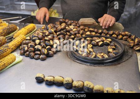 Vendeur de rue vend des châtaignes grillées dans un marché animé d'istanbul Banque D'Images