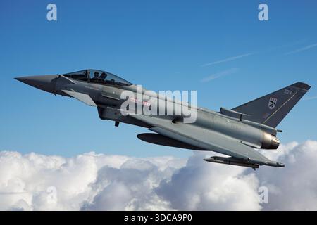 Un Eurofighter EF-2000 Typhoon FGR4 de la Royal Air Force, immatriculé ZK324, code militaire 324, du No. 29 Squadron, est capturé dans une vue air-air rapprochée au RIAT 2025 à la RAF Fairford, en Angleterre. Le chasseur multirôle bimoteur montre le pilote dans le cockpit et affiche les marquages de la RAF. Le Typhoon FGR4 est utilisé pour la défense aérienne, les frappes et les missions d'entraînement opérationnel, démontrant l'avionique avancée, la manœuvrabilité et les performances de vol. Banque D'Images
