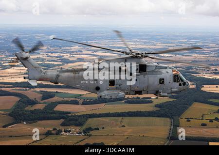 La photographie montre un hélicoptère Merlin HM2 de la Royal Navy désigné EH101 111 et immatriculé ZH832 volant pendant le tatouage aérien Royal International. L'hélicoptère maritime est utilisé pour la guerre anti-sous-marine et les rôles de soutien naval. Il est capturé dans une image air-air au-dessus de la zone près de la RAF Fairford en Angleterre portant les marquages standard de la Royal Navy. Banque D'Images