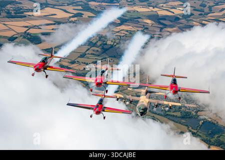 Des avions Royal Jordanian C-130H Hercules 347 et Extra 330LX des Royal Jordanian Falcons volent en formation coordonnée à Riat, combinant transport tactique et vol acrobatique. Banque D'Images