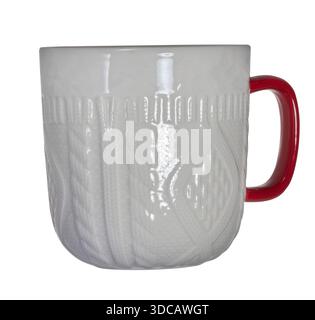 Mug en céramique blanche avec relief tricoté et poignée rouge sur fond isolé Banque D'Images