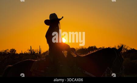 Callie Toth monte au coucher du soleil sur White Stallion Ranch, Marana, Arizona Banque D'Images