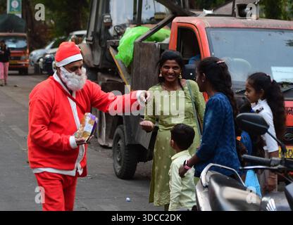 MUMBAI, INDE - 21 DÉCEMBRE : Gurucharan Singh chanceux vêtu d'un costume de Père Noël, distribue des chocolats au peuple, avant la fête de Noël, le 21 décembre 2025 à Mumbai, Inde. Photo de Bhushan Koyande/Hindustan Times les gens célèbrent la fête de Noël Banque D'Images