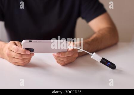 homme utilisant otg usb avec son téléphone portable pour copier des photos Banque D'Images