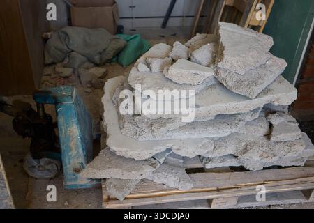 Il y a de nombreux tas de dalles de béton cassées empilées sur une palette en bois robuste Banque D'Images