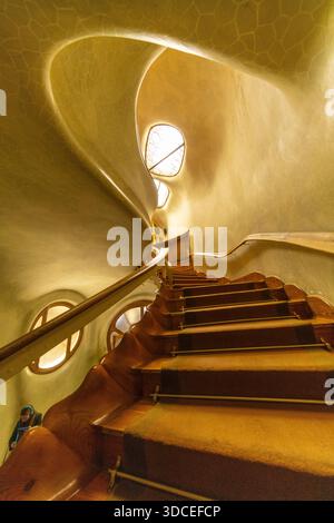 Barcelone, Espagne - 06 novembre 2016 : vue sur l'escalier en spirale de la Casa Batlló, ses courbes organiques et son éclairage chaleureux projetant de douces ombres sur le t Banque D'Images