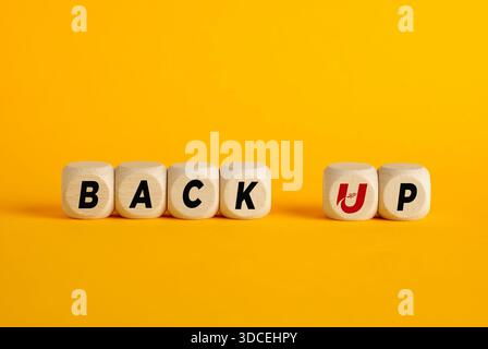 Cubes en bois avec le mot back up sur fond jaune. Concept de sauvegarde des données. Banque D'Images