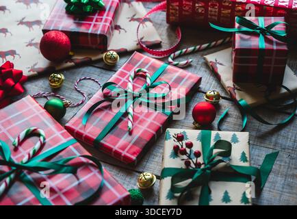 Gros plan de cadeaux de Noël enveloppés en rouge et vert avec des rubans. Banque D'Images