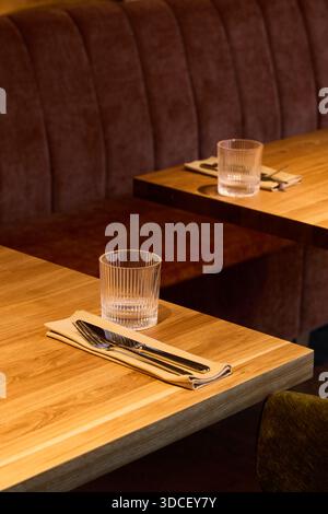 Des tables vides sont aménagées pour le dîner dans un restaurant moderne Banque D'Images