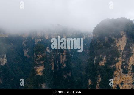 Vue aérienne de majestueux piliers de grès perçant à travers la brume éthérée, mettant en valeur la grandeur de la nature, parc forestier national de Zhangjiajie, Zhangjiajie, Banque D'Images