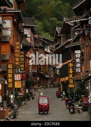 Qiandongnan, Chine - 30 septembre 2025 : vue sur le paysage urbain captivant avec des bâtiments en bois, des toits sombres et des panneaux vibrants créant une riche ta Banque D'Images