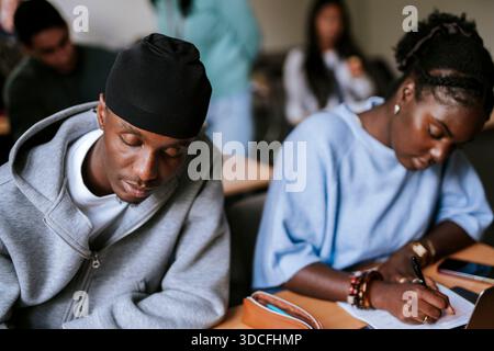 Jeune étudiant masculin concentré portant Do Rag étudiant à l'université en classe Banque D'Images