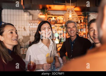 Groupe d'amis joyeux passant du temps libre ensemble dans un cocktail au bar Banque D'Images