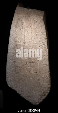 Cordoue, Espagne - 21 mai 23 : une ancienne tablette de pierre avec des inscriptions et des sculptures, exposée sous un éclairage tamisé, mettant en valeur l'importance historique Banque D'Images