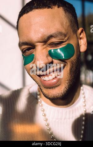 Portrait d'un homme souriant avec un patch sous les yeux faisant un clin d'œil à la caméra Banque D'Images