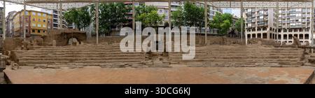 Vue panoramique sur les ruines antiques avec des marches en pierre et des murs, entouré de bâtiments modernes et d'arbres, sous une structure de protection de la Théa romaine Banque D'Images