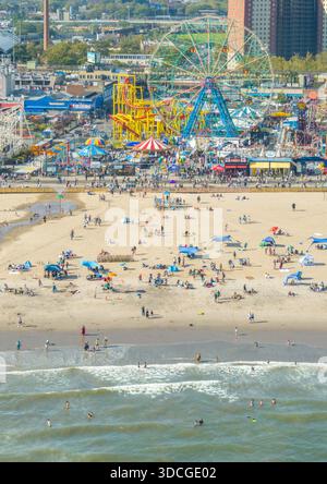 Vue aérienne des sables ensoleillés rencontre le vibrant parc d'attractions Coney Island, une tapisserie de couleurs et une activité joyeuse, Brooklyn, New York, United Sta Banque D'Images