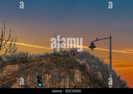 Landmark a concentré la Croix de pierre monumentale sur la colline Gellért surplombant Budapest à l'heure d'or avec Citadella Liberty Statue Banque D'Images