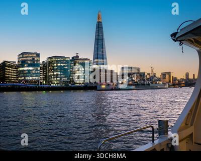 PAYSAGE URBAIN DE SOUTHBANK AU CRÉPUSCULE LUMIÈRES SHARD vue au sud de la rivière au crépuscule depuis le bateau Thames Clipper jusqu'au HMS Belfast, The Shard et plus encore London place SE1 Southbank London UK Banque D'Images