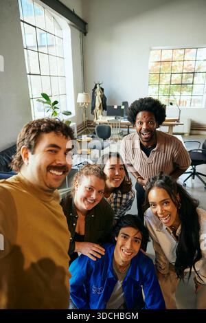 Portrait d'homme d'affaires heureux prenant selfie avec des collègues dans le bureau de démarrage Banque D'Images