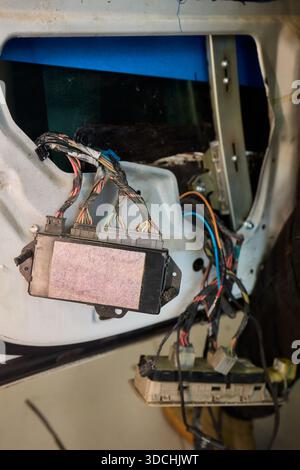 Une vue rapprochée détaillée des mains connectant divers fils dans un système électrique complexe de voitures Banque D'Images