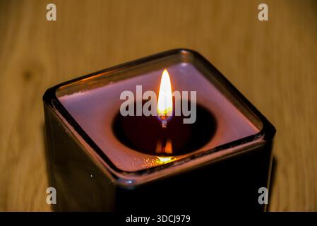 Une bougie allumée transforme instantanément l’énergie d’un espace, passant d’un éclairage fonctionnel à une expérience sensorielle profonde. Banque D'Images