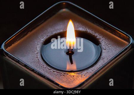 Une bougie allumée transforme instantanément l’énergie d’un espace, passant d’un éclairage fonctionnel à une expérience sensorielle profonde. Banque D'Images
