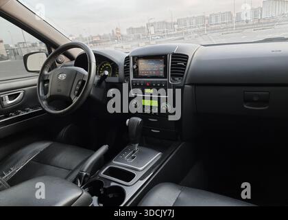 Intérieur de KIA Sorento en fin d'après-midi. Vue grand angle du panneau avant de la voiture : sièges en cuir, volant, tableau de bord, menu radio à l'écran. Banque D'Images