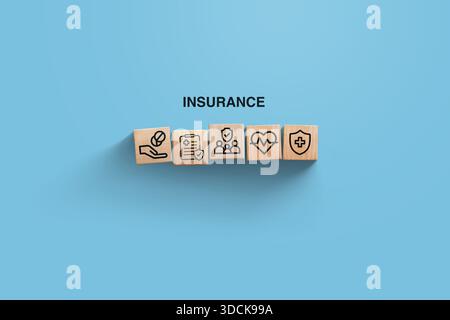 assurance, idée créative. Blocs en bois avec des icônes d'assurance médicale sur fond bleu, vue de dessus. Santé et assurance, concept Banque D'Images