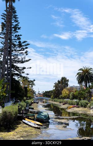 Canal de Venise bordé de palmiers, de maisons et de petits bateaux sous ciel bleu, Venice Beach, Los Angeles, Californie, États-Unis Banque D'Images