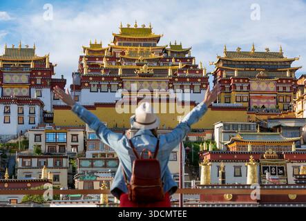 Shangrila Chine, femme posant devant le monastère de Songzanlin au coucher du soleil à Shangri-la Yunnan Chine Banque D'Images