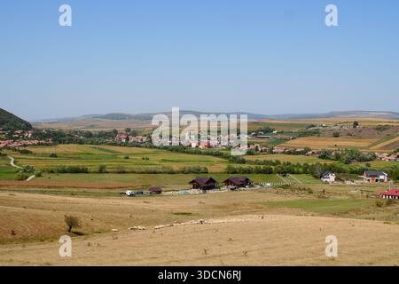 Voyage roumanie transilvania Cheile turzii vue panoramique sur la campagne avec des bâtiments, des champs cultivés, des collines lointaines, et le pâturage des moutons Banque D'Images