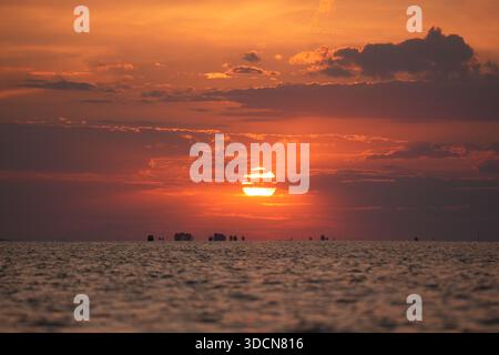 Voyage roumanie tulcea sulina danube delta mer noire soleil plongeant sous l'horizon peignant ciel et eau avec une lumière orange et rouge chaude Banque D'Images