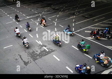 Bangkok, Thaïlande - 20 octobre 2024 - motocyclistes naviguant sur une route urbaine à plusieurs voies sous un pont supérieur, marquée par des flèches directionnelles et des séparateurs de voies Banque D'Images