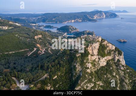 Vaste paysage aérien avec les ruines historiques d'Angelokastro sur un précipice avec en toile de fond les baies côtières sinueuses de Paleokastritsa et le b. Banque D'Images
