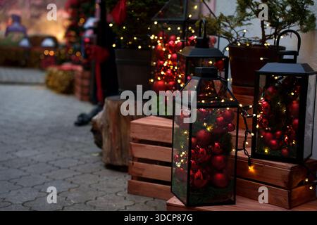décoration extérieure festive avec des ornements rouges et des lumières chaudes éclairant les marches en bois rustiques et la verdure en pot, capturant une atmosphère de noël confortable Banque D'Images