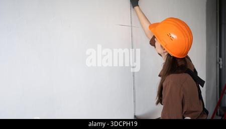 architecte dans le mur de mesure de casque dur utilisant la règle en acier. architecture et concept de rénovation de la maison. bannière Banque D'Images