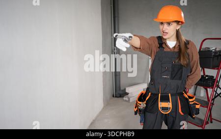 Femme bâtisseuse. Angry Female Architect pointant du doigt sur vous dans le bâtiment inachevé. réparation, construction et concept de construction. bannière. copier l'espace Banque D'Images