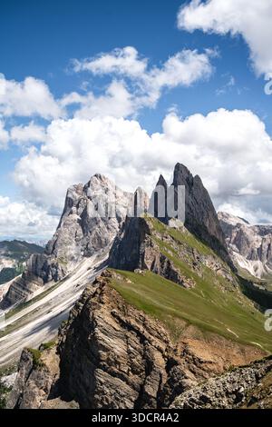Vue spectaculaire sur les sommets Odle de Seceda dans le Val Gardena, Dolomites. Des flèches calcaires pointues s'élèvent au-dessus des crêtes alpines vertes sous un ciel bleu vif Banque D'Images