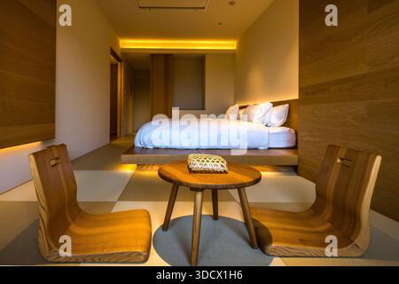 Deux chaises en bois et une table avec un panier se trouvent dans une pièce moderne de l'hôtel Kuroshio Sou à Shirahama, une propriété de onze chambres près de la plage. Préfecture de Wakayama, Japon. Banque D'Images