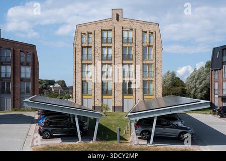 Les voitures sont garées sous un auvent avec des panneaux solaires dans un nouvel immeuble. Énergie durable et ombre en même temps Banque D'Images