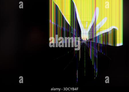 Gros plan d'un écran endommagé montrant des fissures radiales et des lignes de pépins colorées sur une surface noire, soulignant le dysfonctionnement matériel, la rupture et le repai Banque D'Images